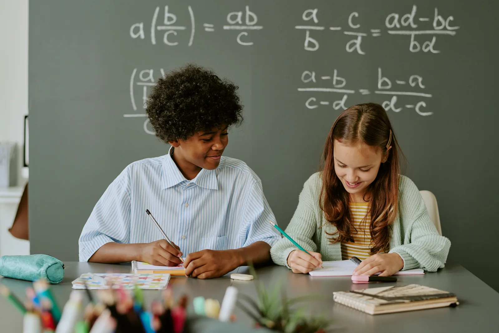 Teenagers solving maths problems together in a classroom
