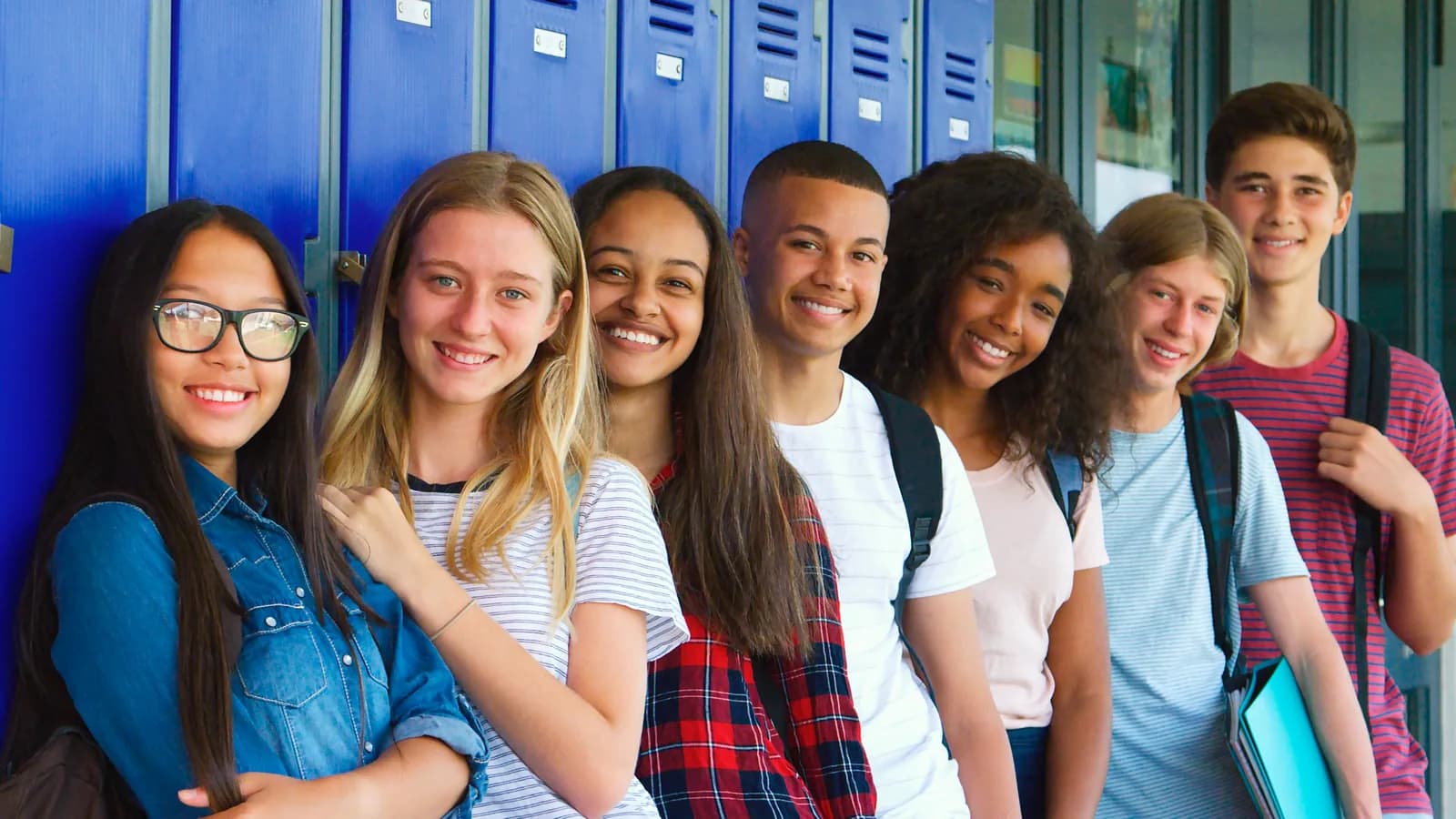A group of secondary students standing together outside school