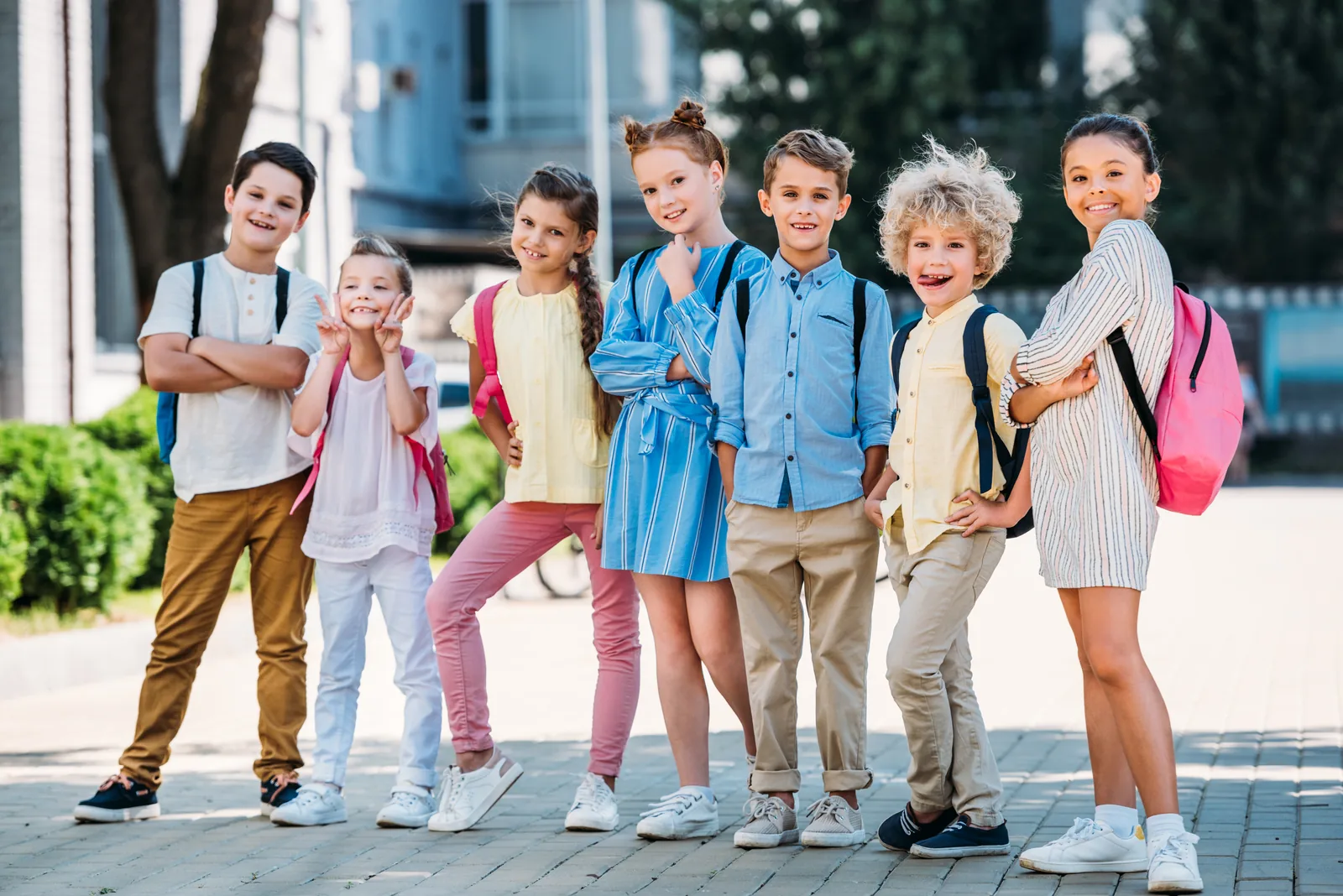 Students with backpacks standing together outside their school