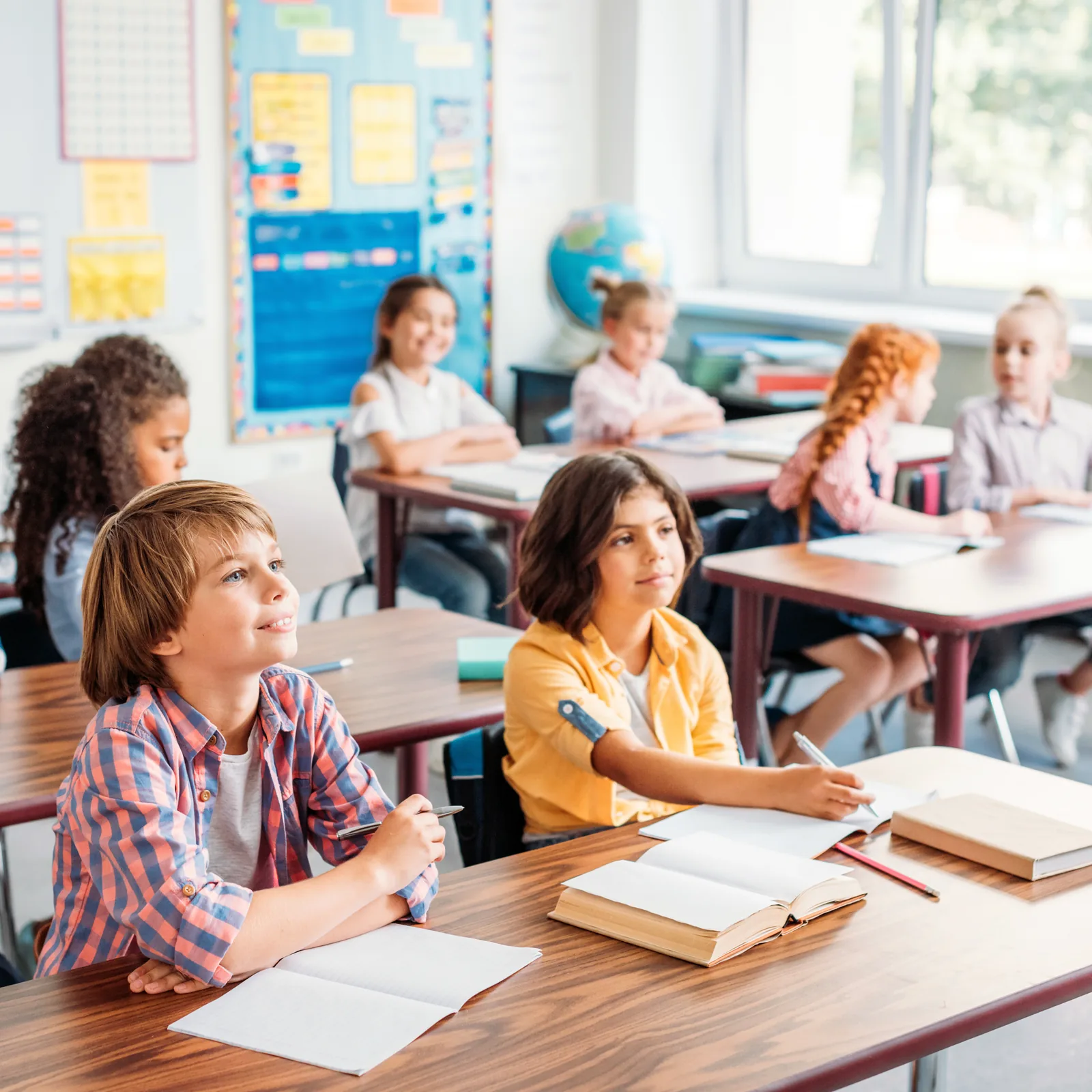 Students working at desks in a bright US elementary classroom
